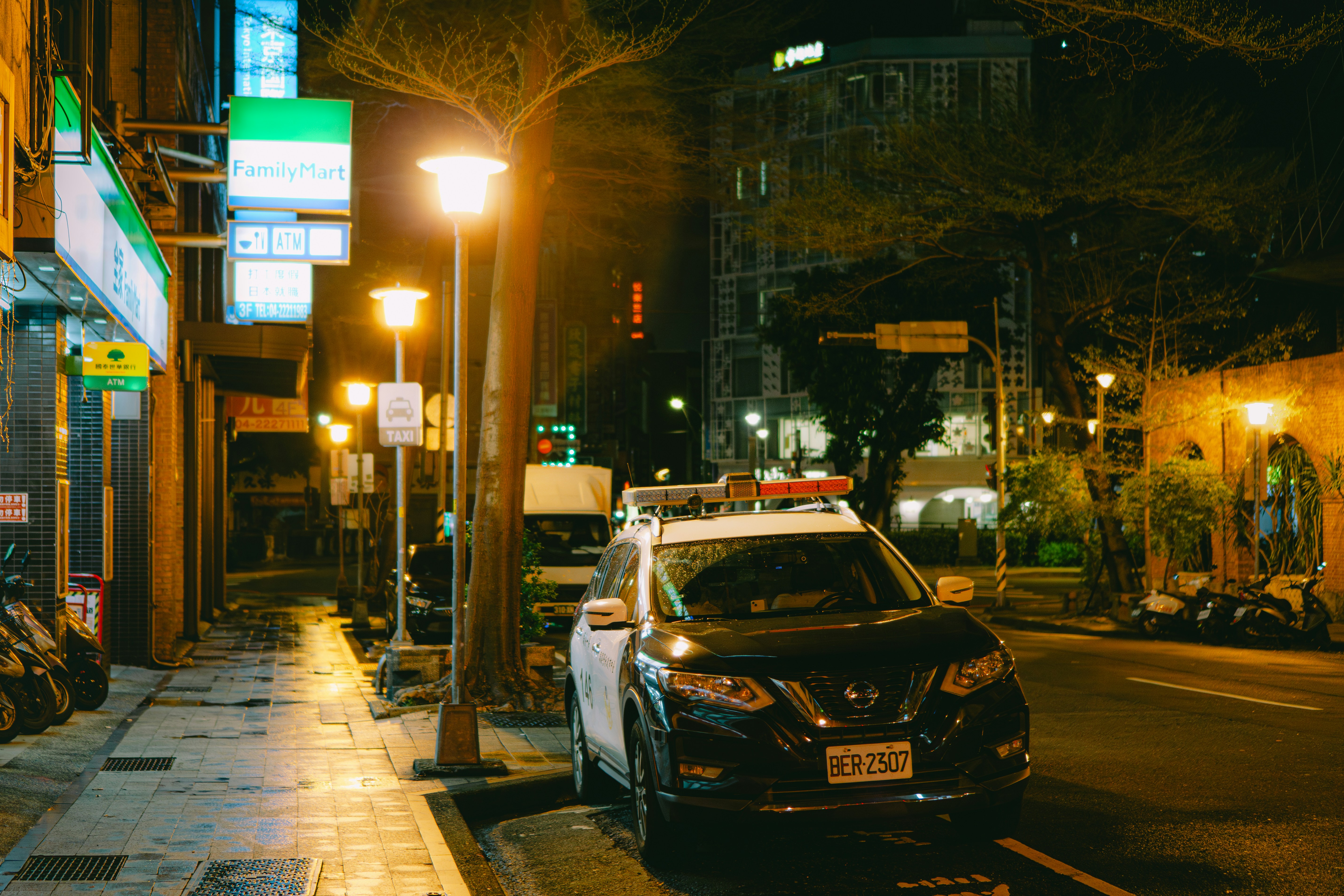 Compact electric city car plugged into a curbside charger in a modern city