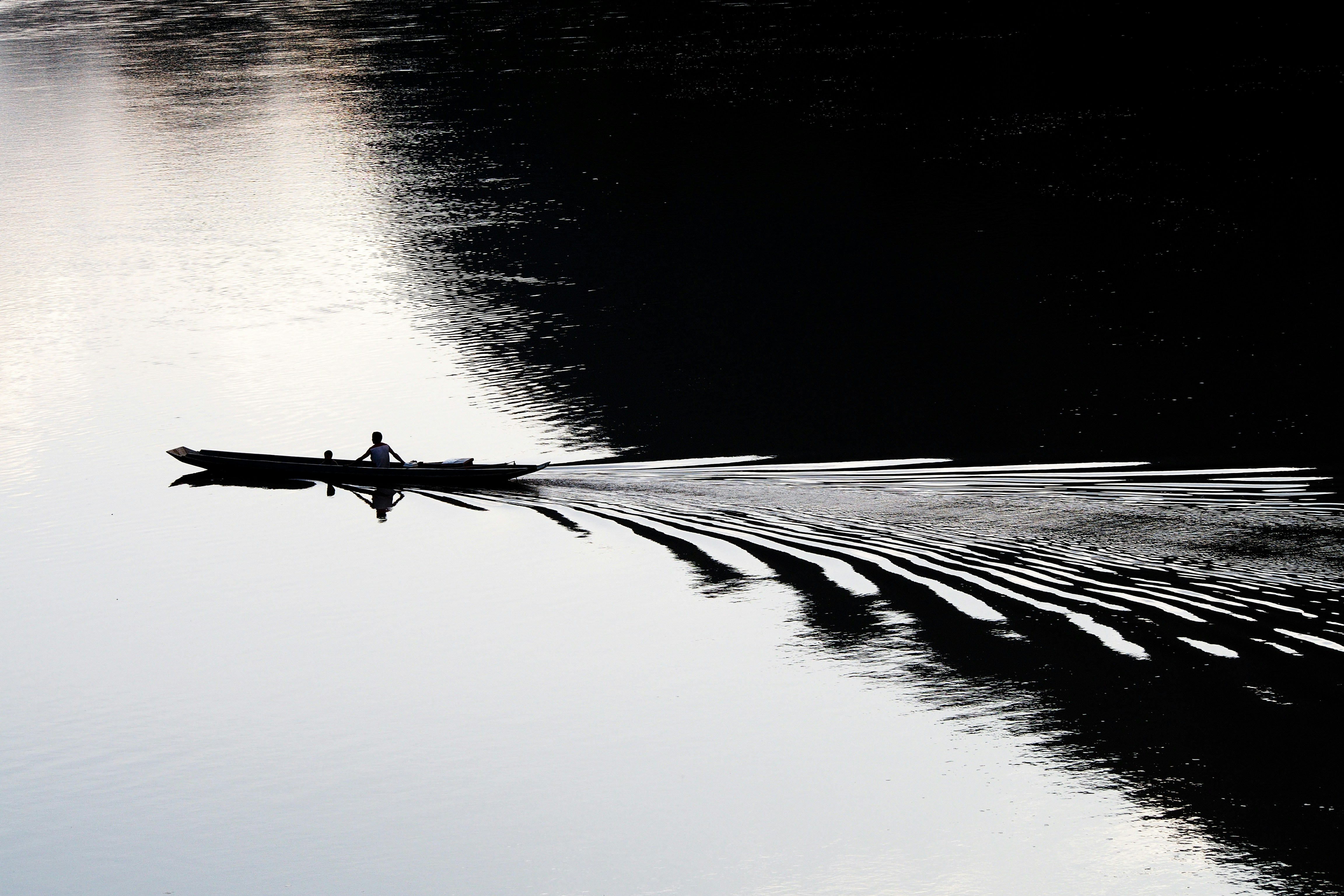 Eine Person paddelt mit einem Boot auf dem Wasser.
