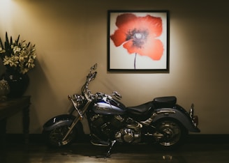 A motorcycle sits beneath flower art.