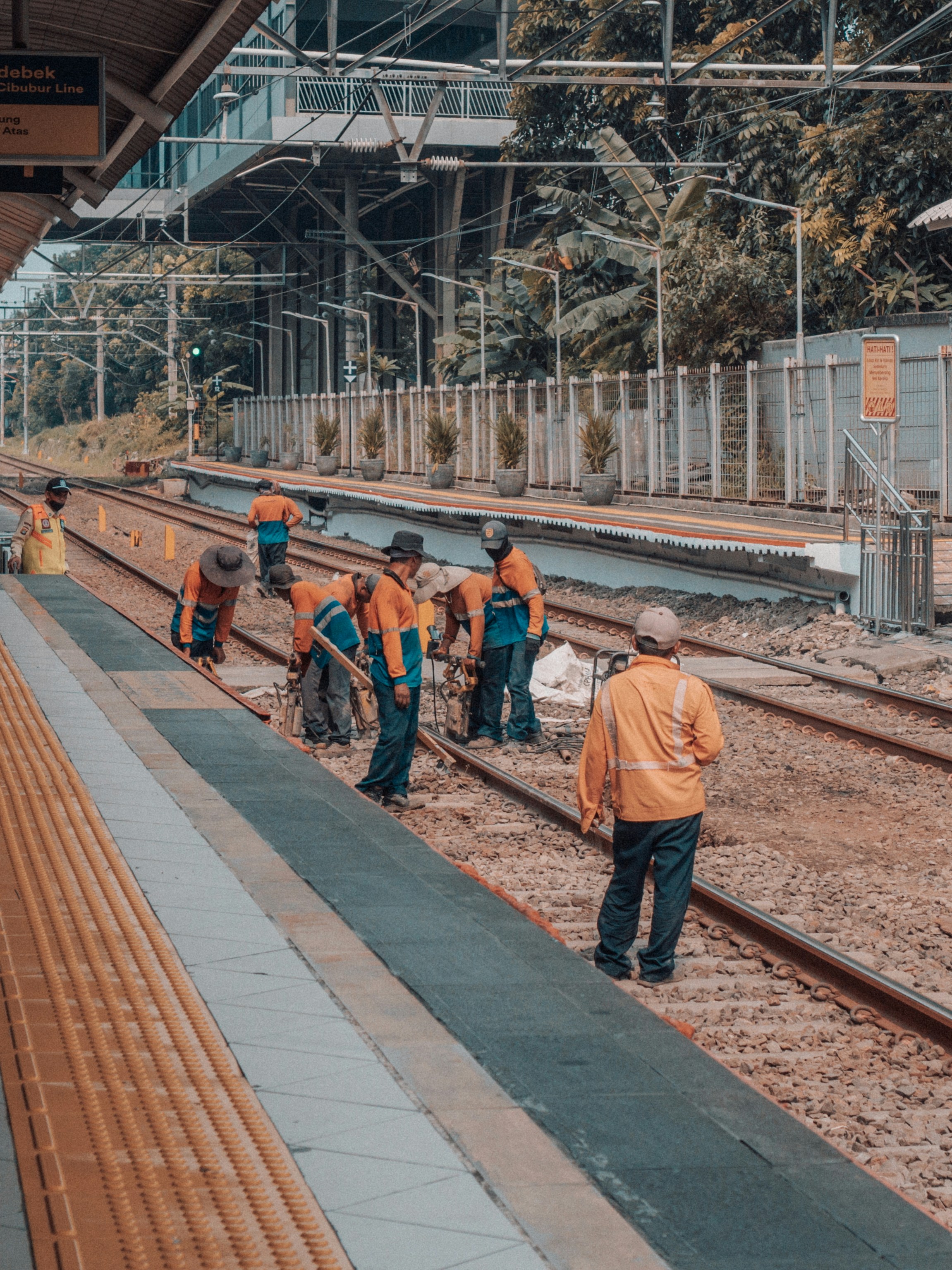 Workers are repairing the train tracks on a platform.