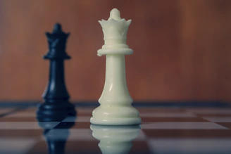 Black and white queens face each other on a board.