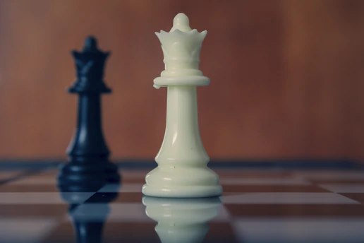 Black and white queens face each other on a board.