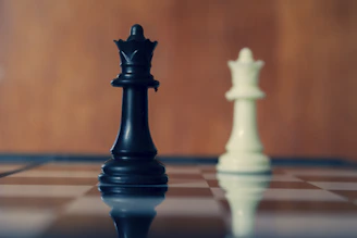Black and white queens stand on the chessboard