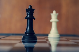 Black and white queens stand on the chessboard.