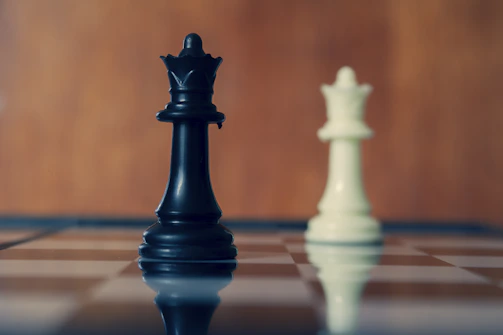 Black and white queens stand on the chessboard