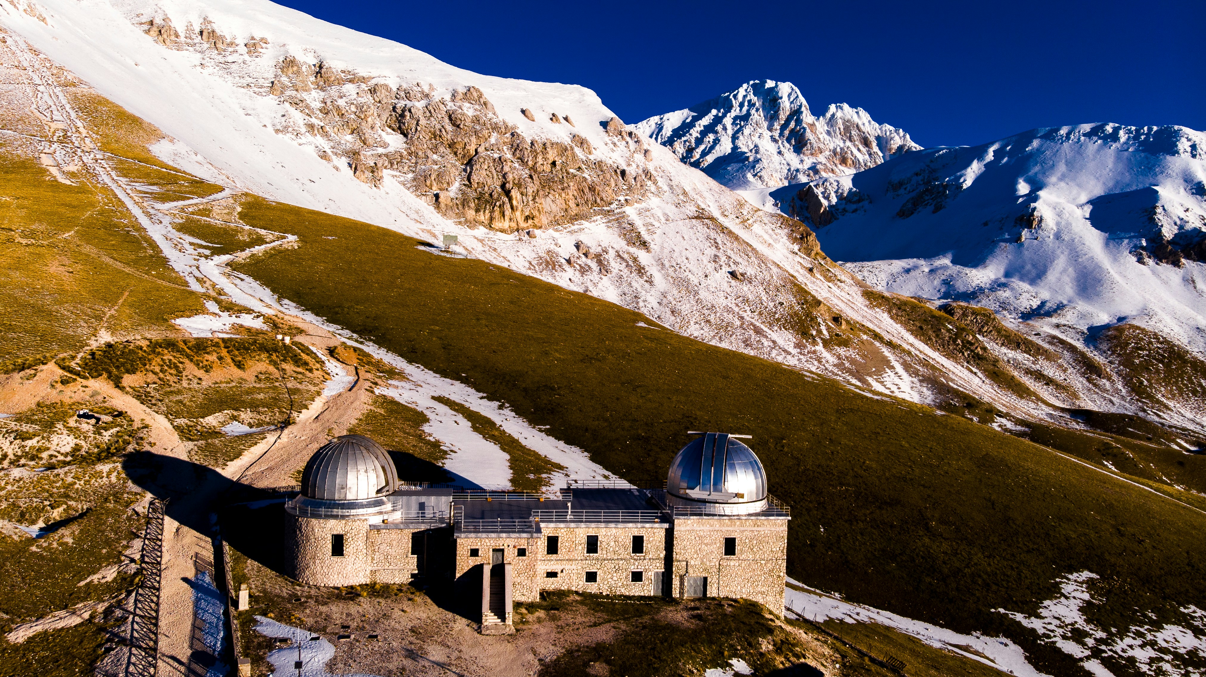Un osservatorio si trova sotto le cime innevate delle montagne.
