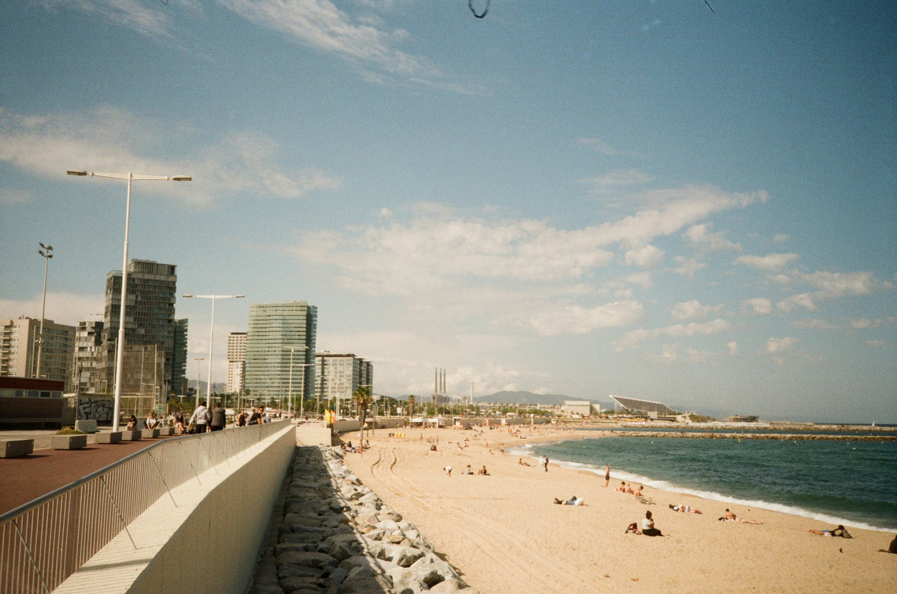 A beach in barcelona with buildings in the background.