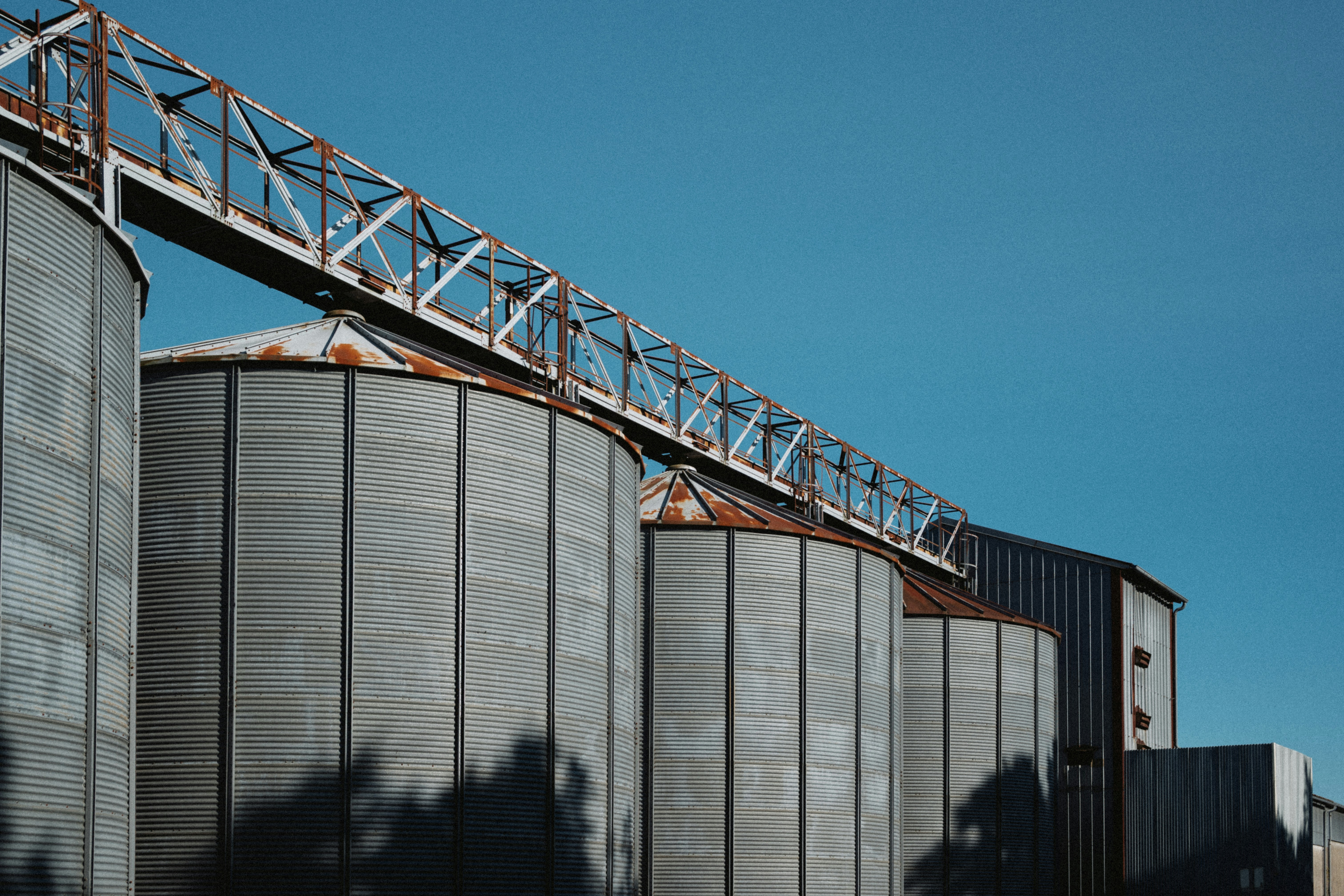 Grain silos stand beneath a blue sky.