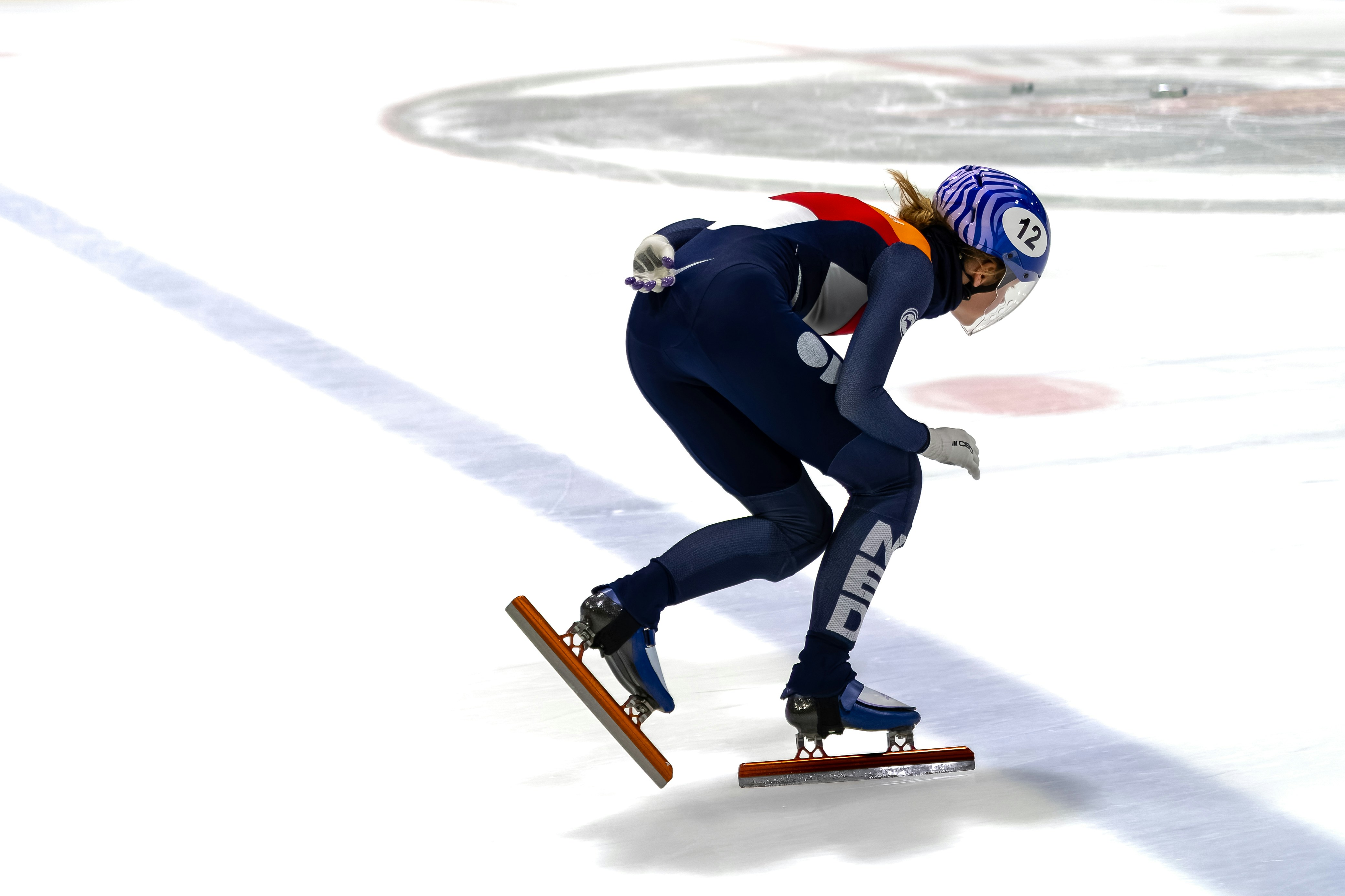 A skater speeds around the ice track. photo – Free Image on Unsplash