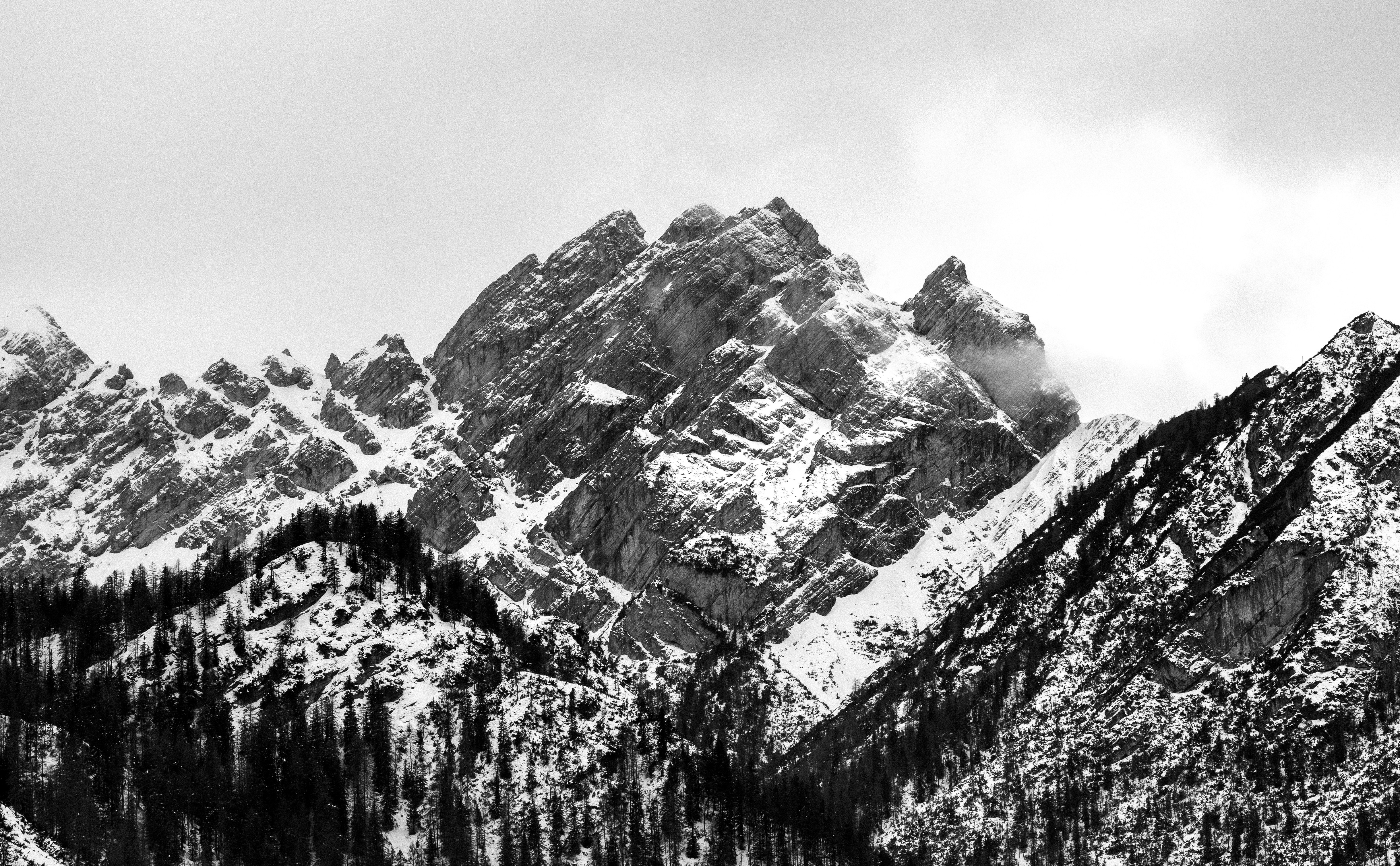 Snowy mountains rise against a cloudy sky.