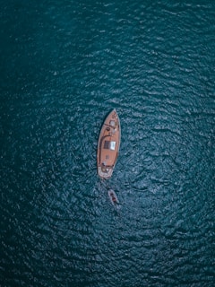 A boat sails calmly through the vast ocean.