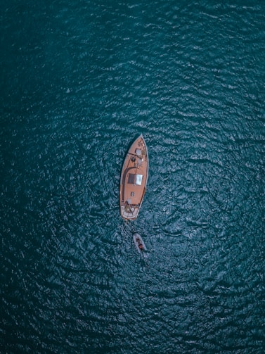 A boat sails calmly through the vast ocean.