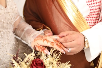 A groom places a ring on a bride's finger.