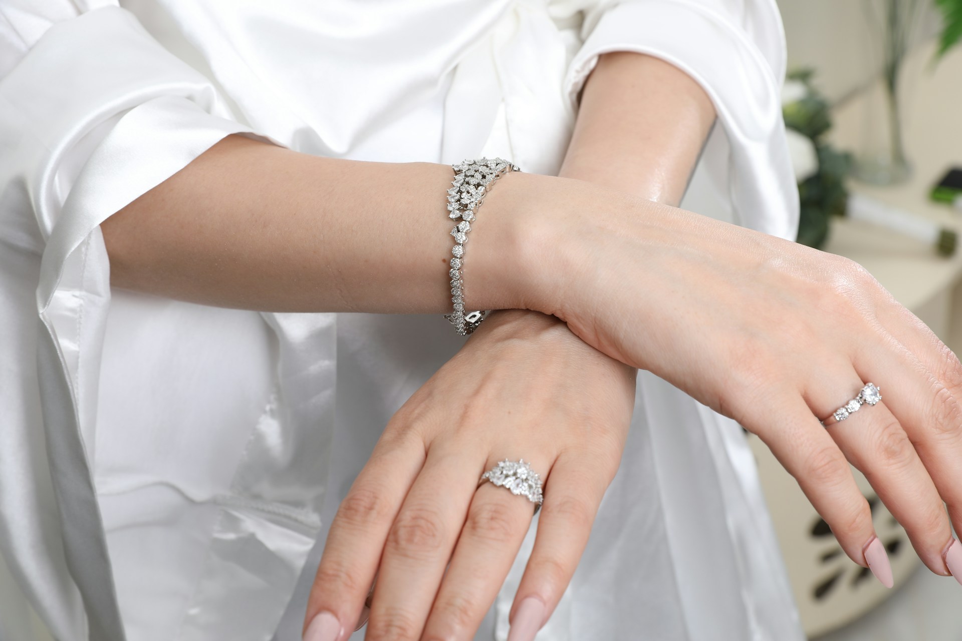 Jewelry adorns a woman's hands and wrist.