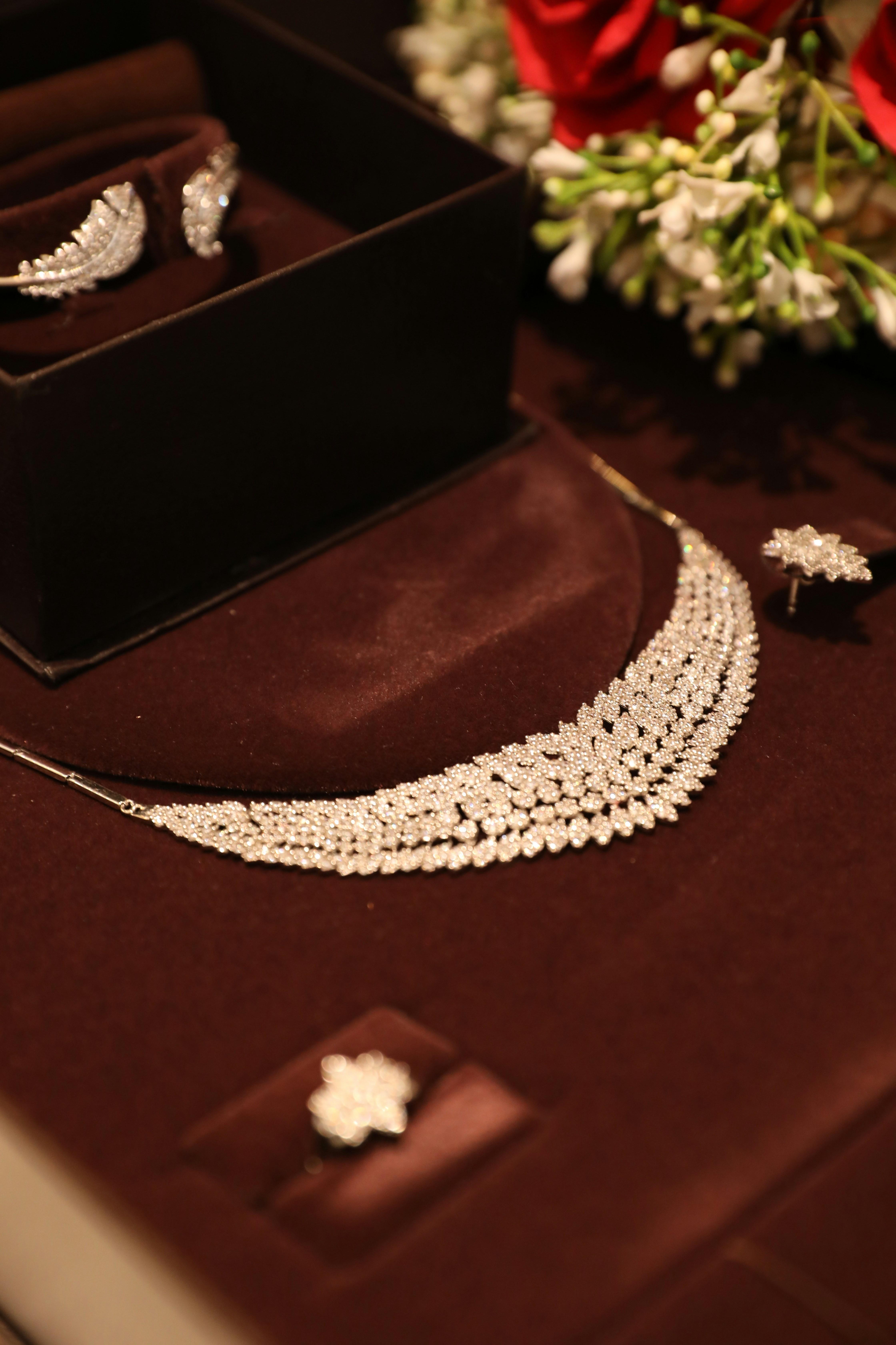 Diamond jewelry is displayed on a red surface.