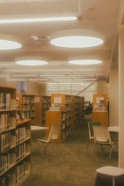 A library interior with bookshelves and chairs.
