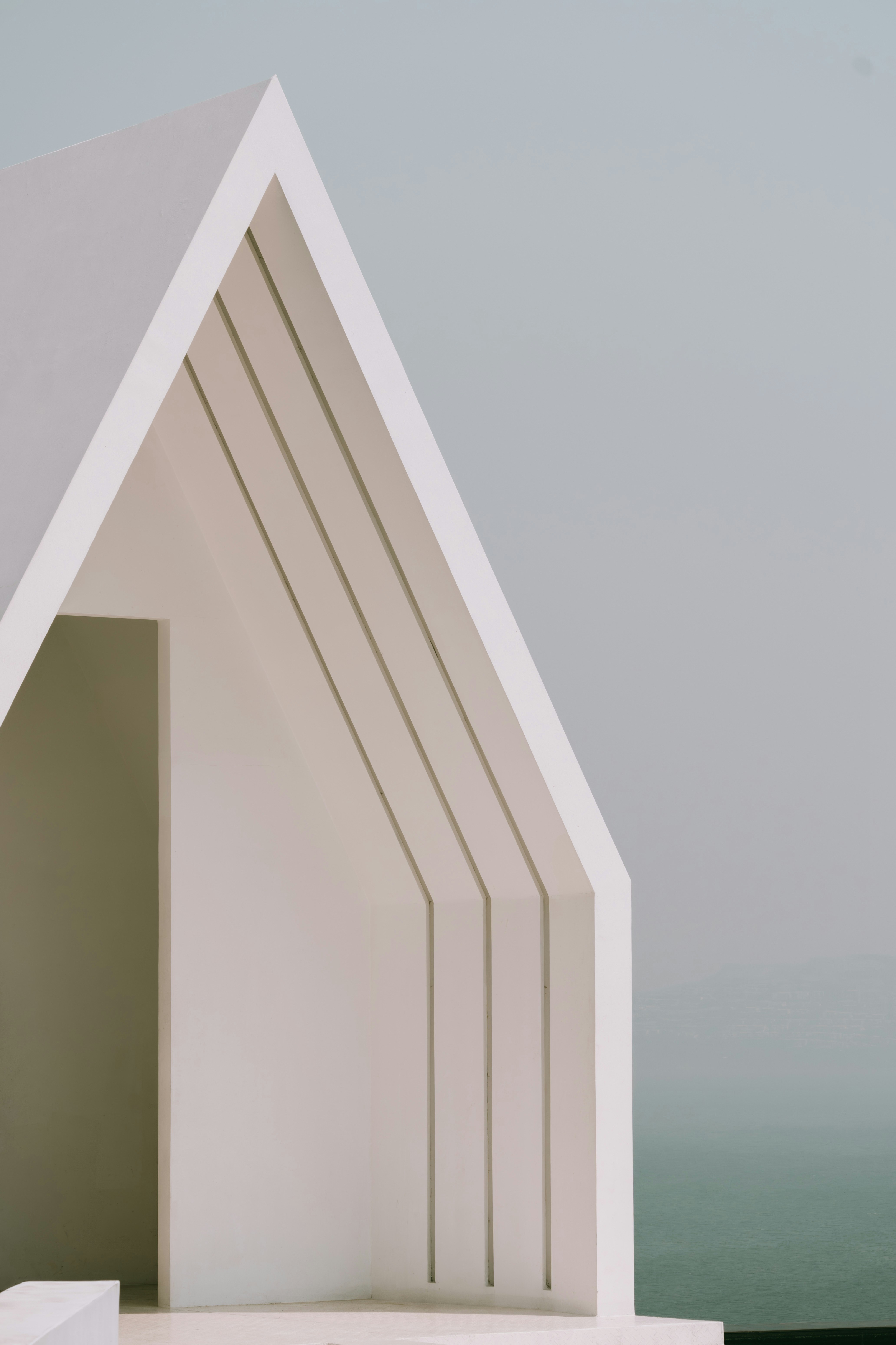 Edifício branco minimalista com um design arquitetónico único.