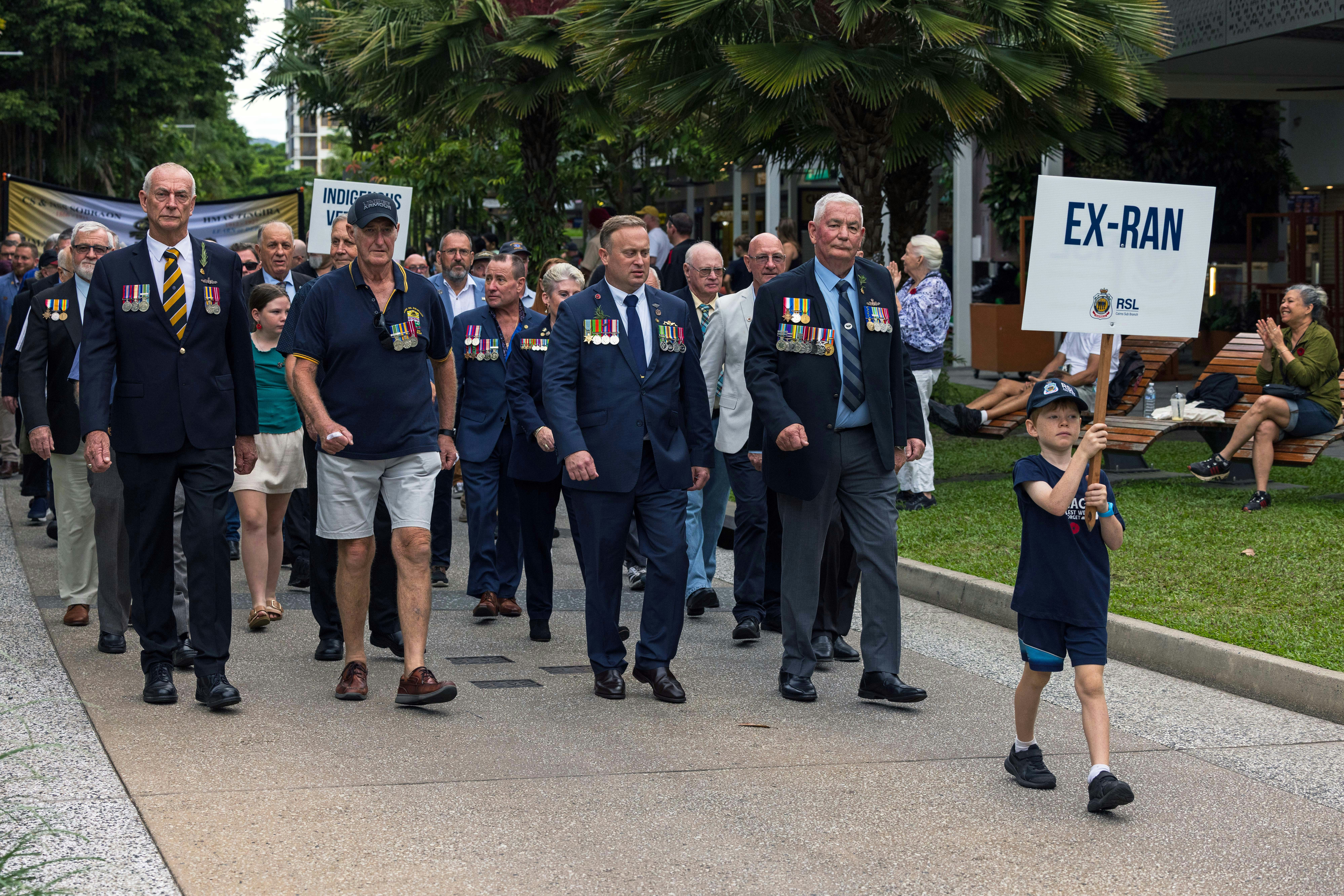 Veterans are marching in a parade with a child - historic armories