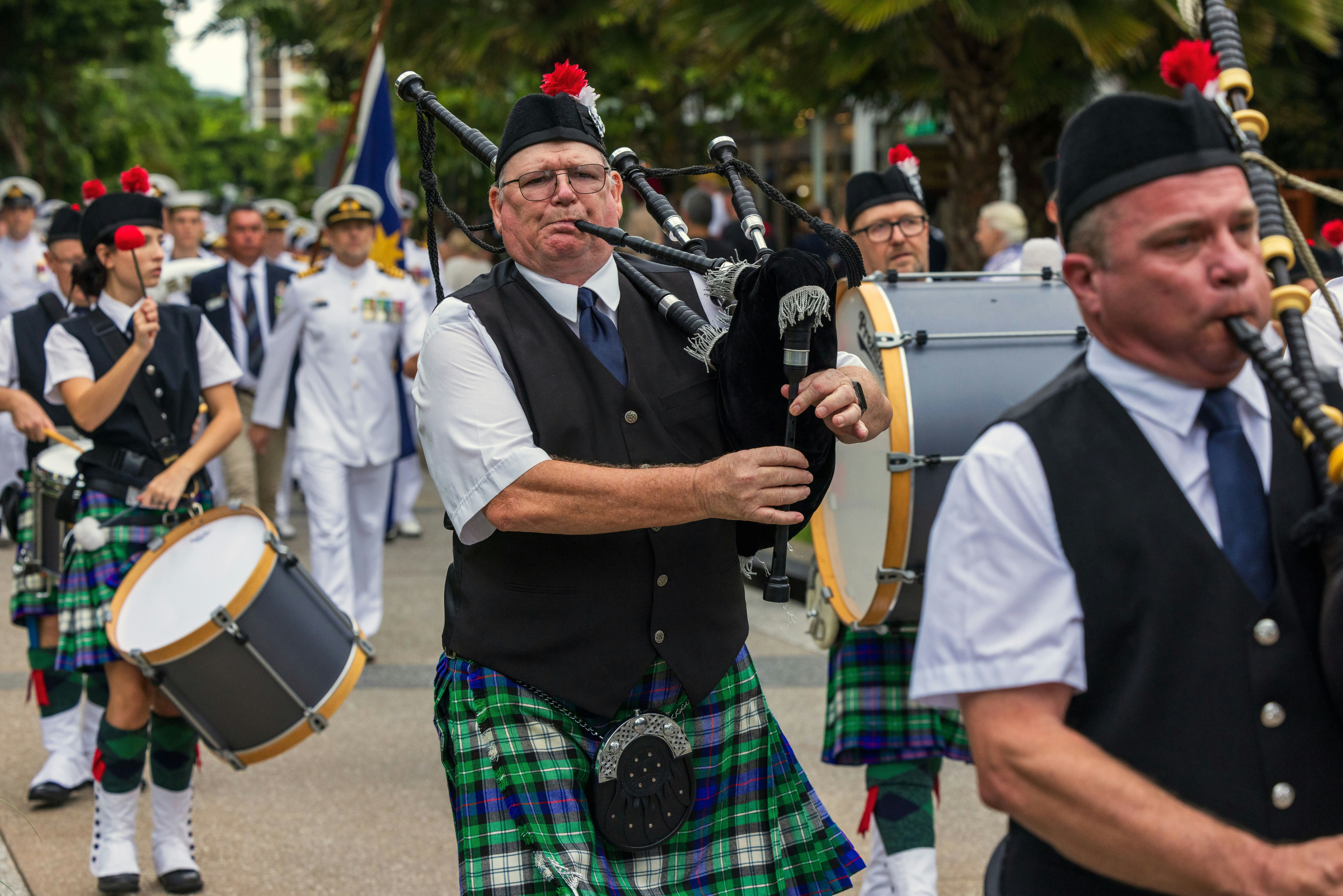 A bagpipe band marches in a parade.