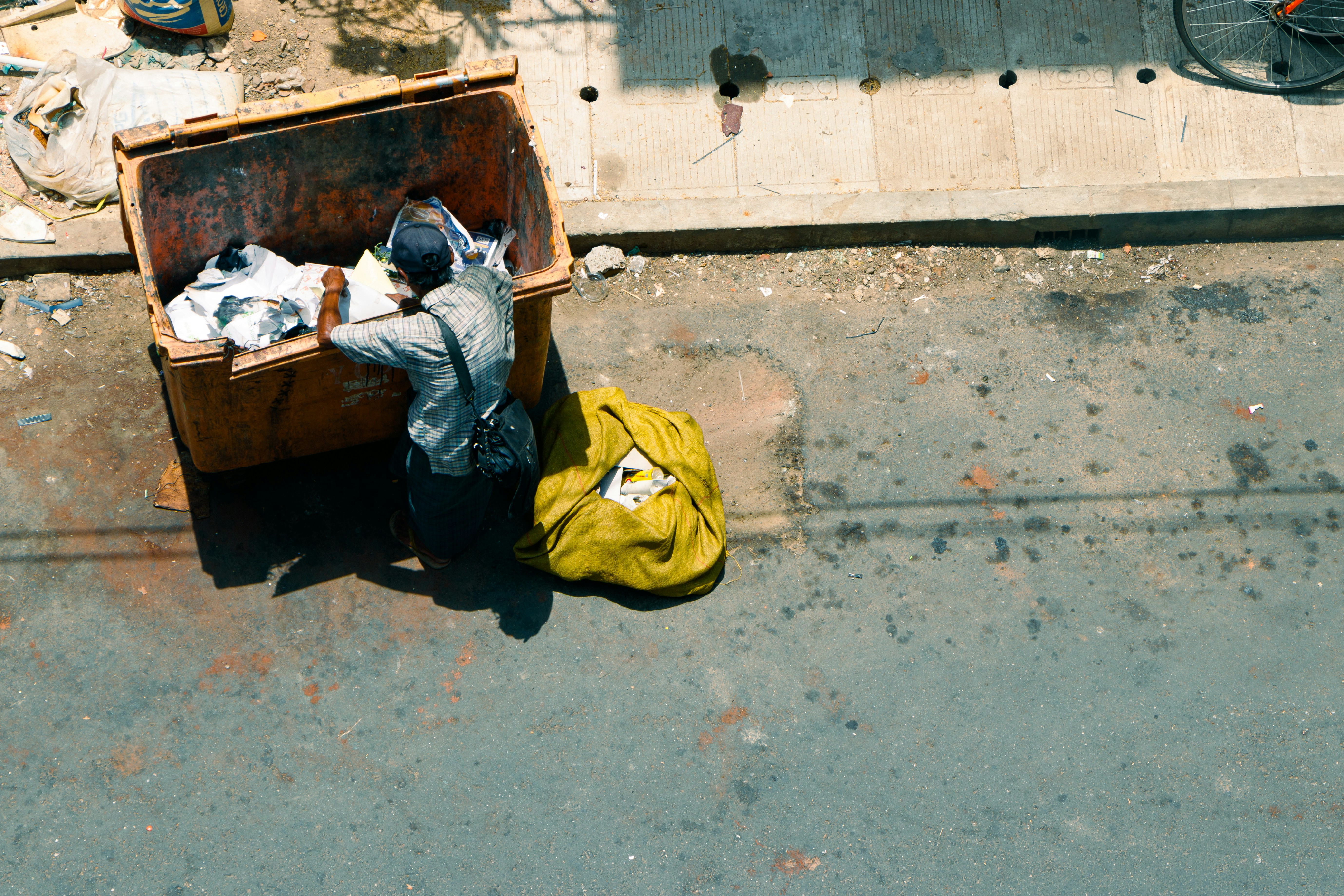 A person sorts through a dumpster for recyclables.