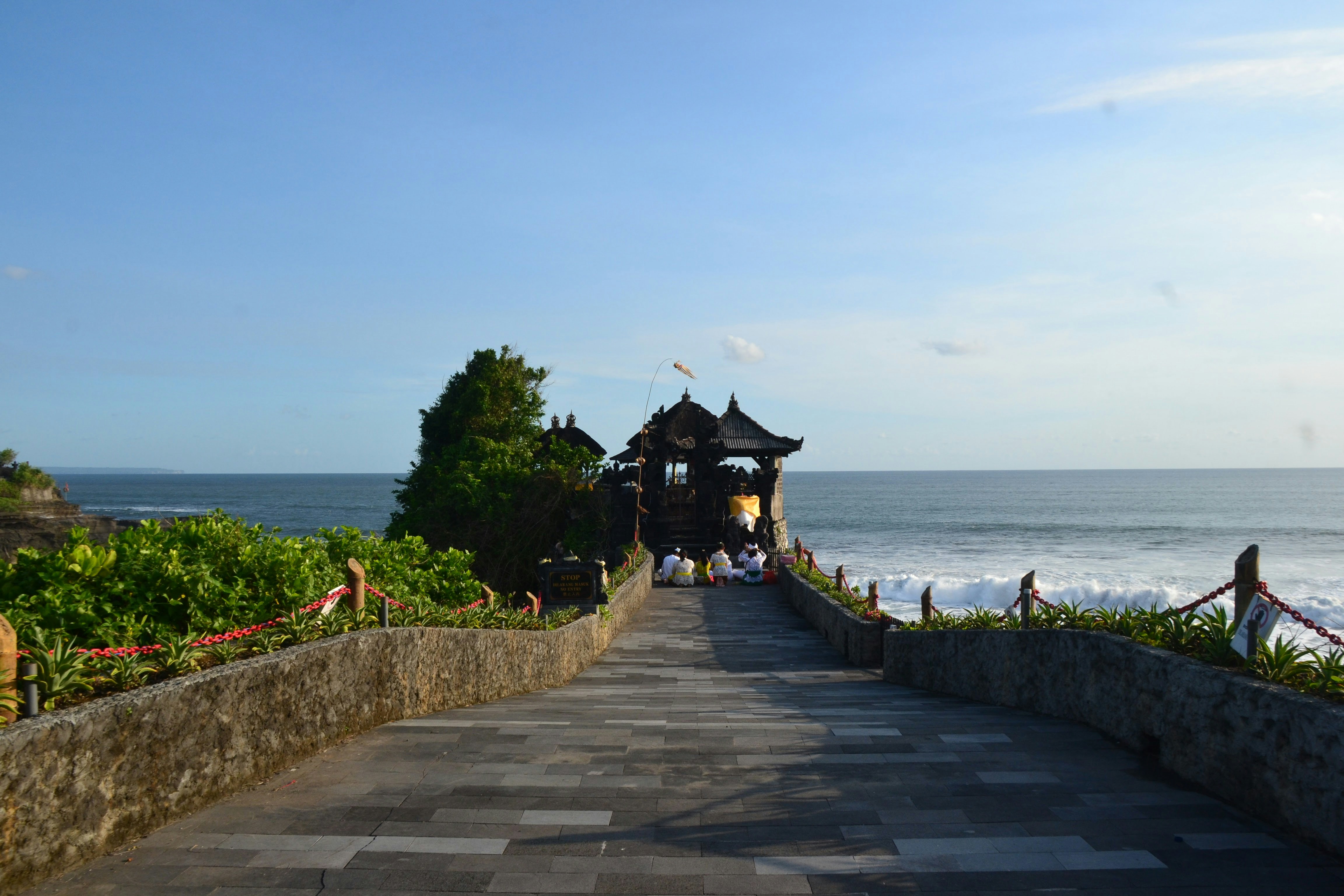 A temple pathway leads to the ocean.