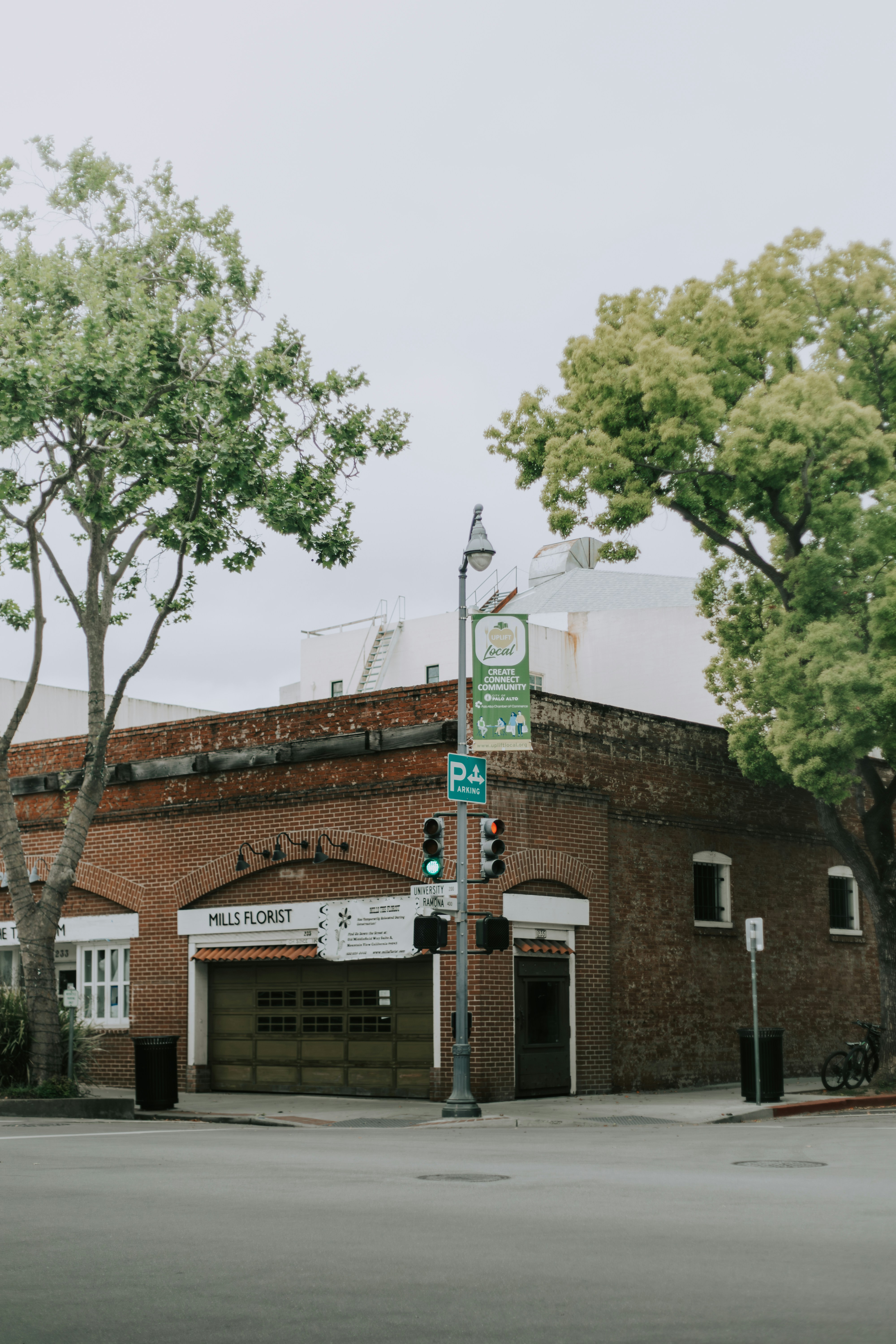 A brick building with trees and a street corner.