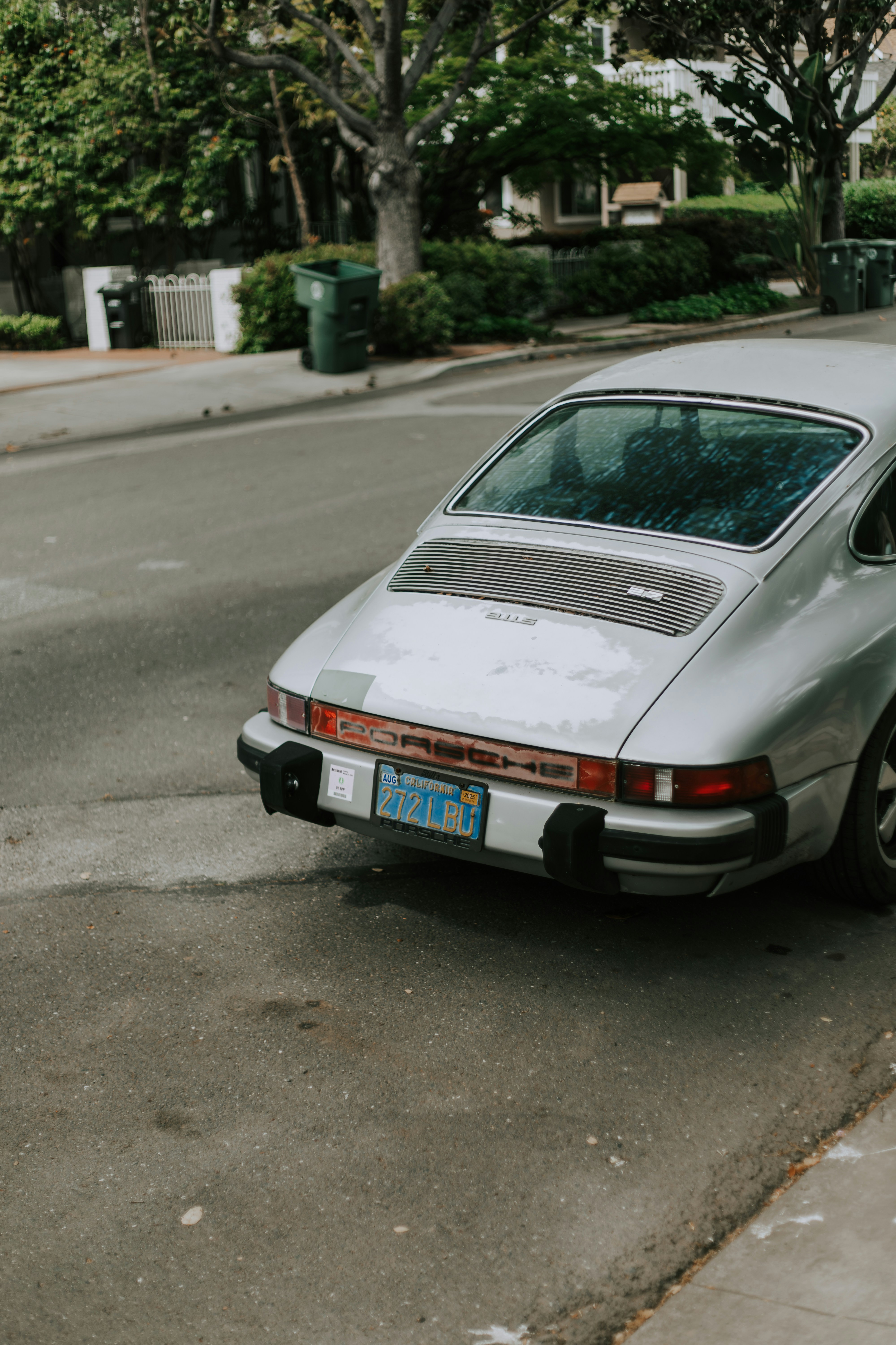 Silver classic car parked on a city street.