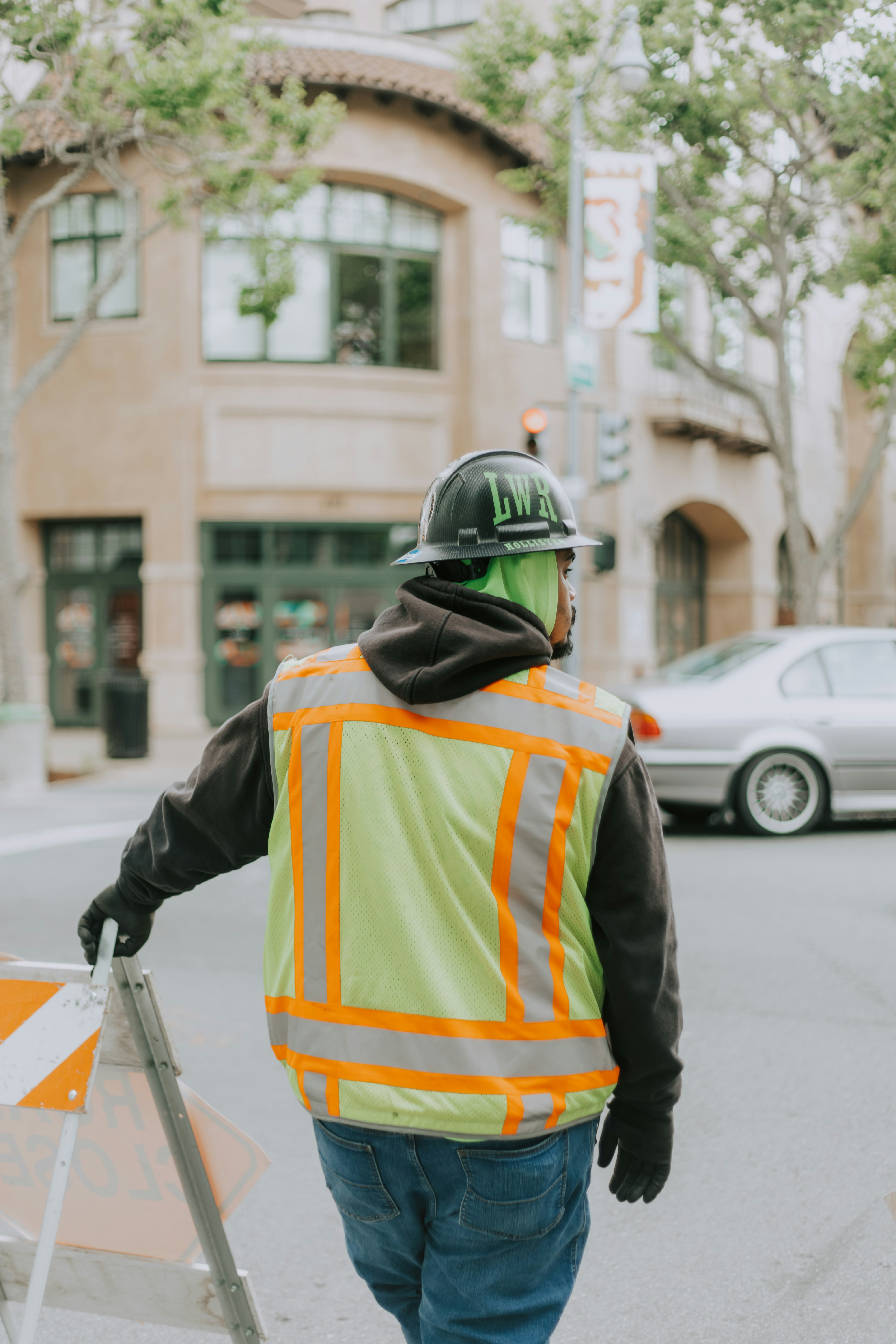 Construction worker stands at a city intersection.