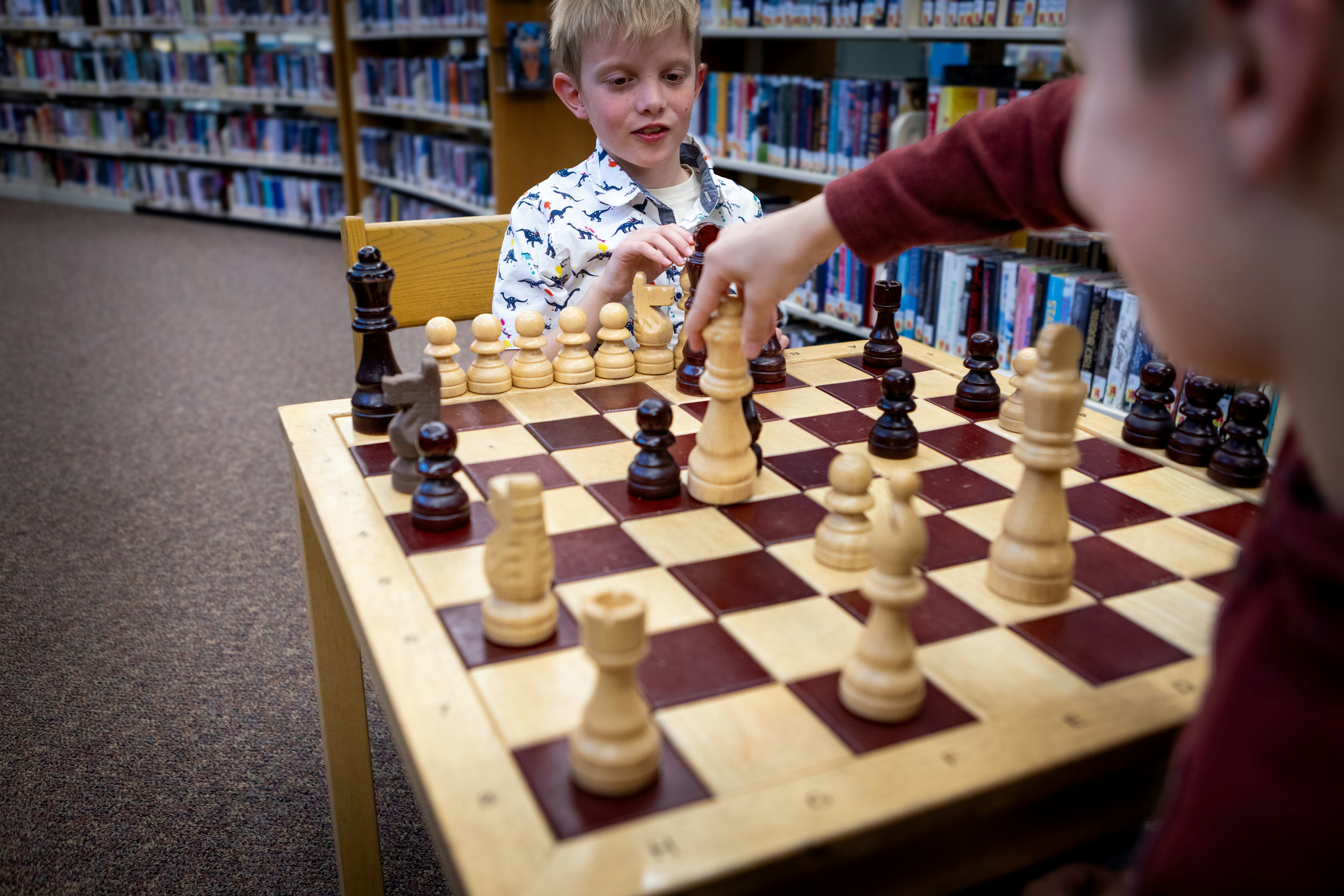 Children learning chess at library