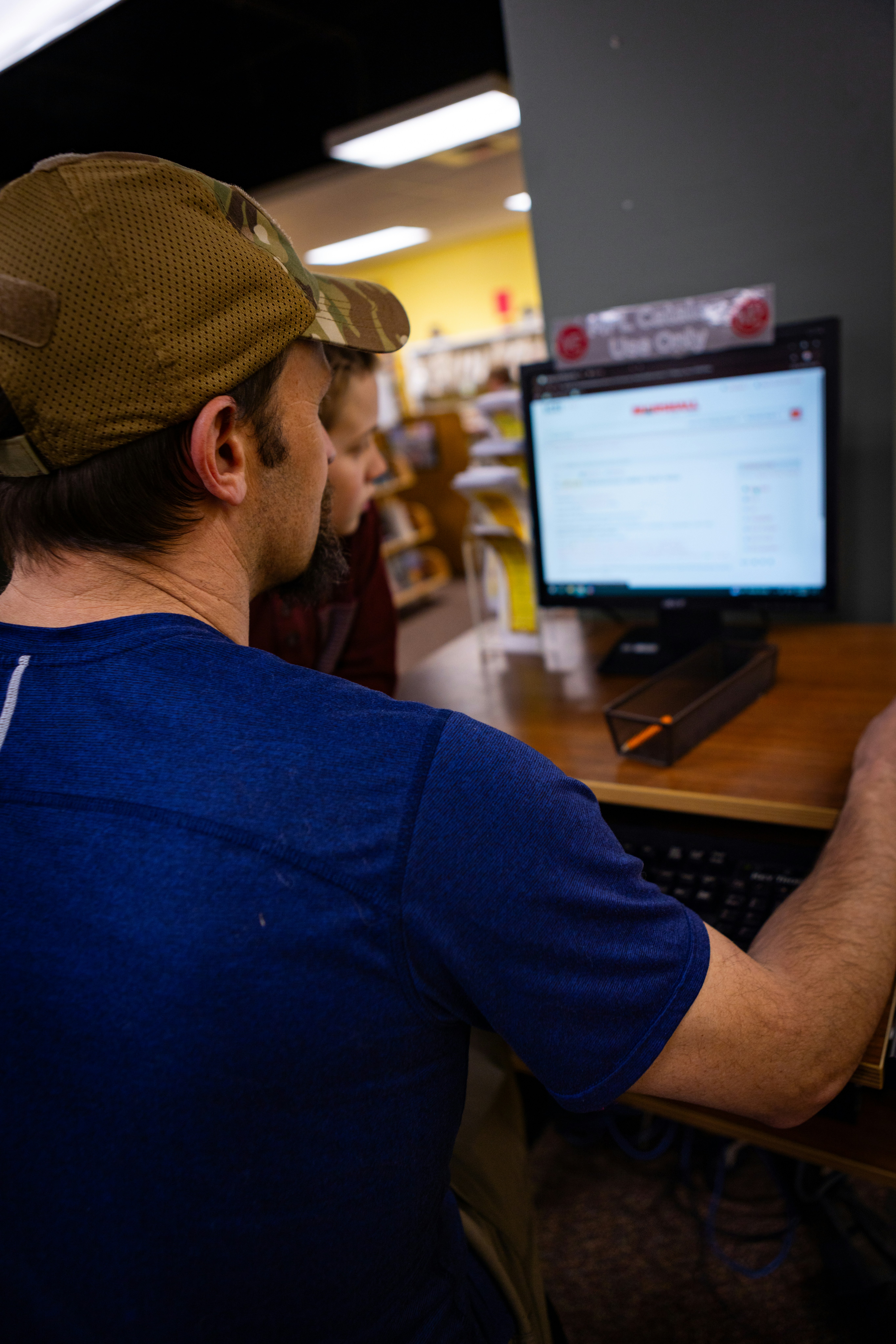 A man and boy work together on a computer.