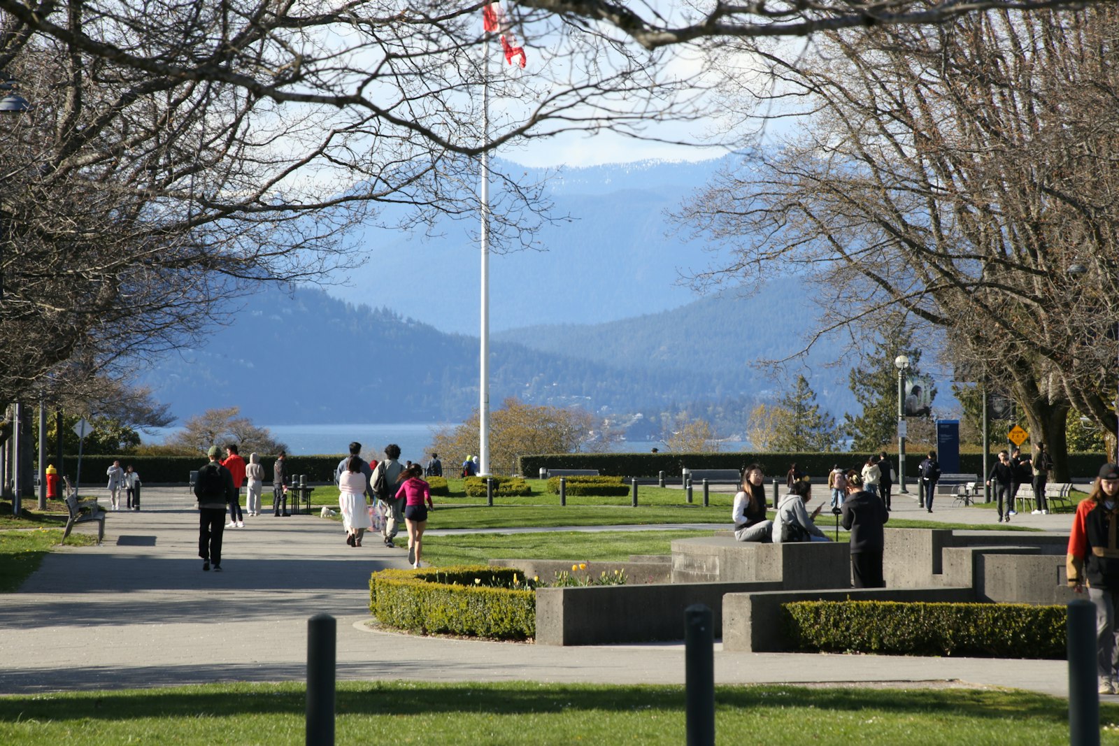 People walking on a Canadian campus with mountains in the background