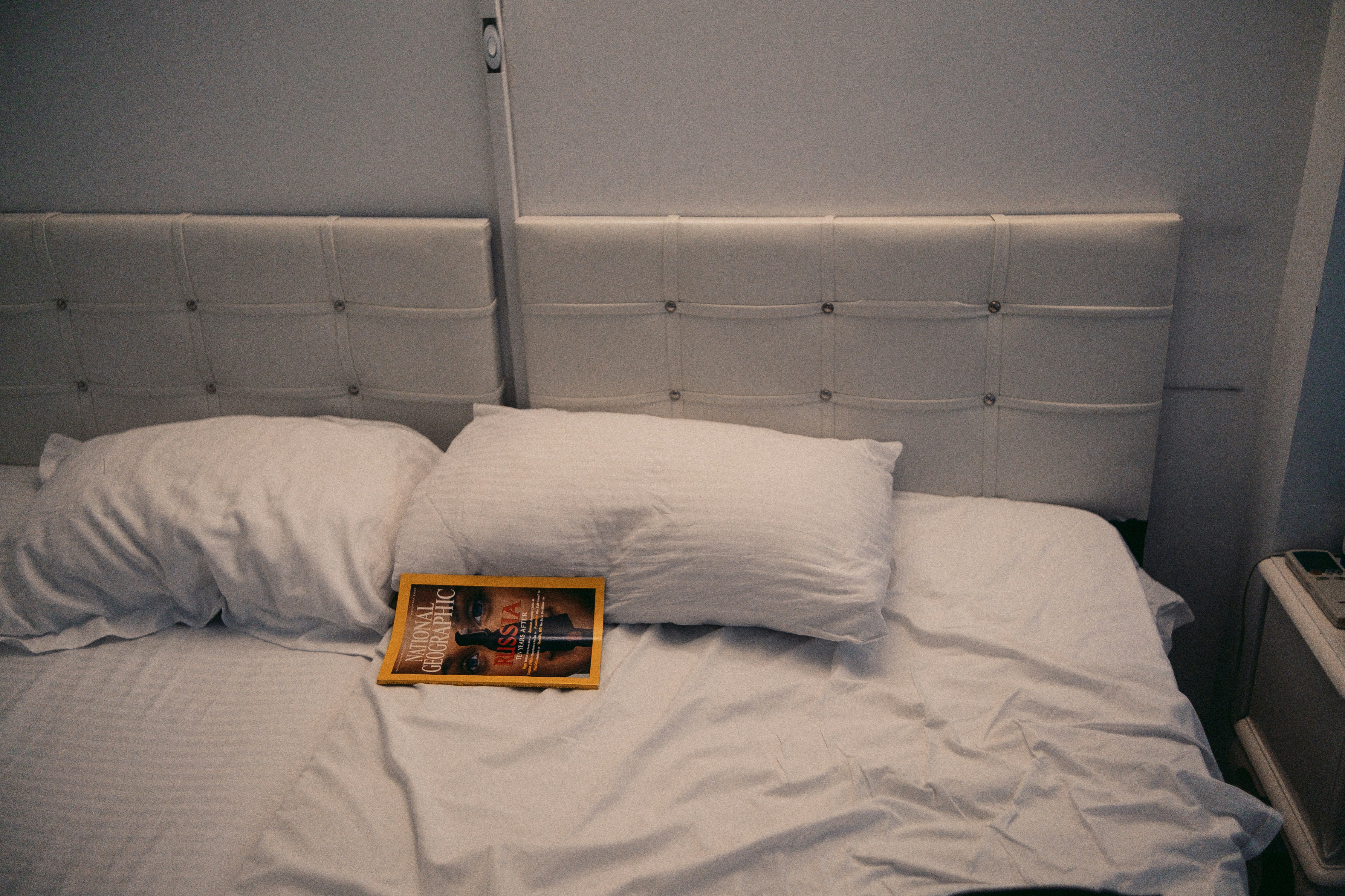 A bed is made with white pillows and sheets.