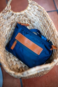 A blue bag rests in a wicker basket.