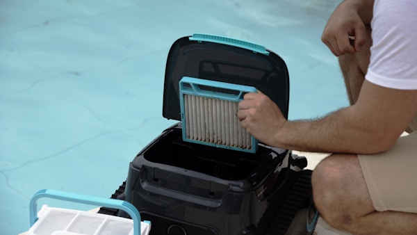 Person removing the filter from a pool cleaning robot for maintenance