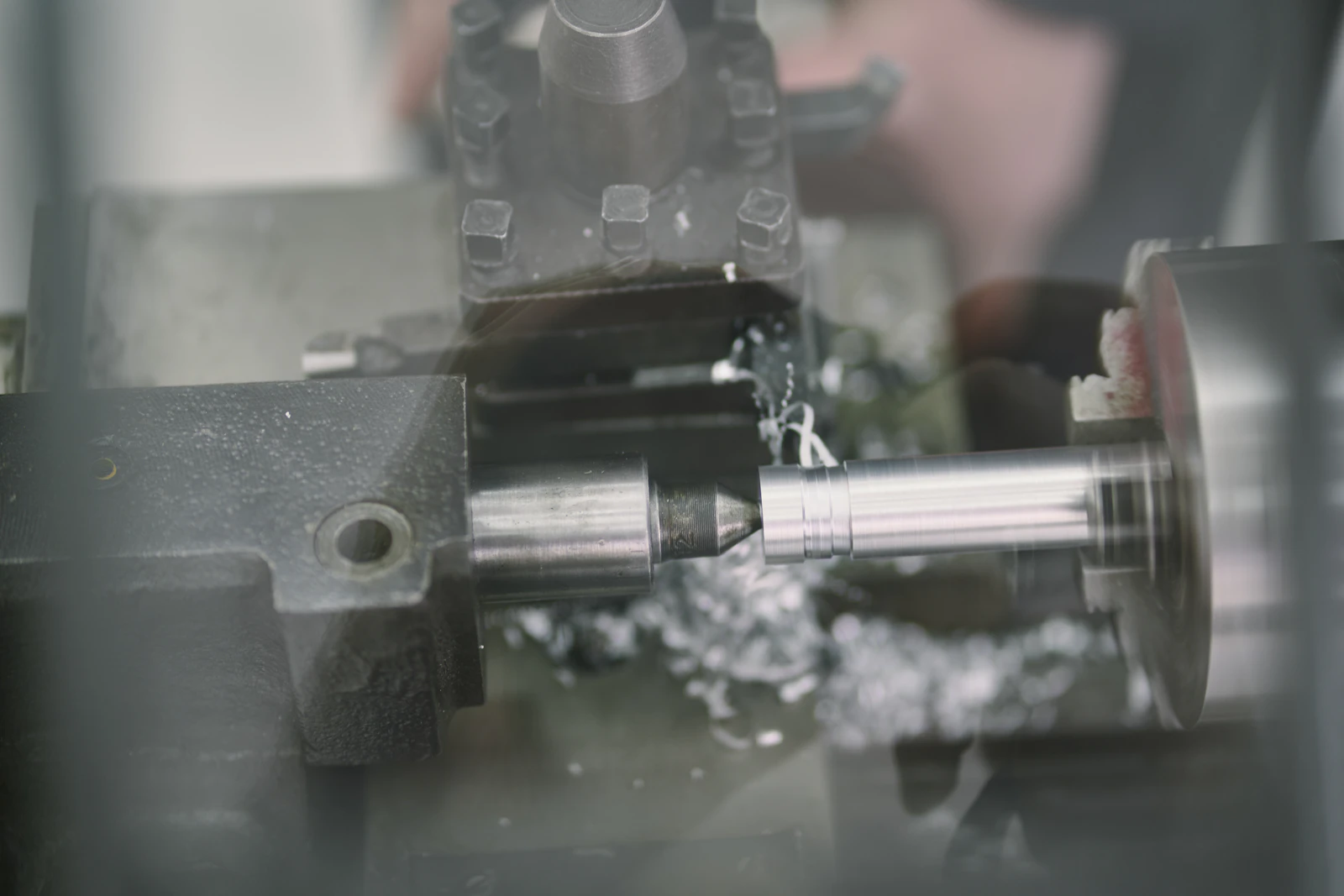 Metal lathe actively shaping a steel rod with cutting tools