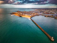 Aerial view of a coastal city with a long pier
