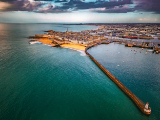 Aerial view of a coastal city with a long pier.