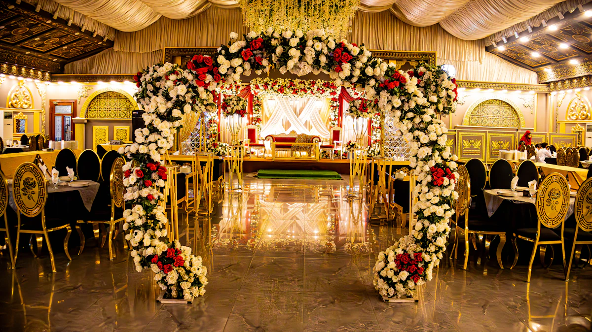 Reception stage with floral drapery and warm uplighting