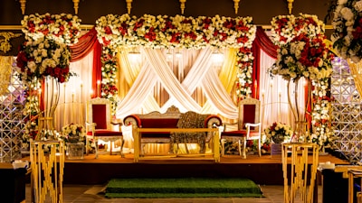 Wedding stage decorated with flowers and drapery.