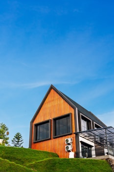 A modern house stands tall under a clear blue sky.