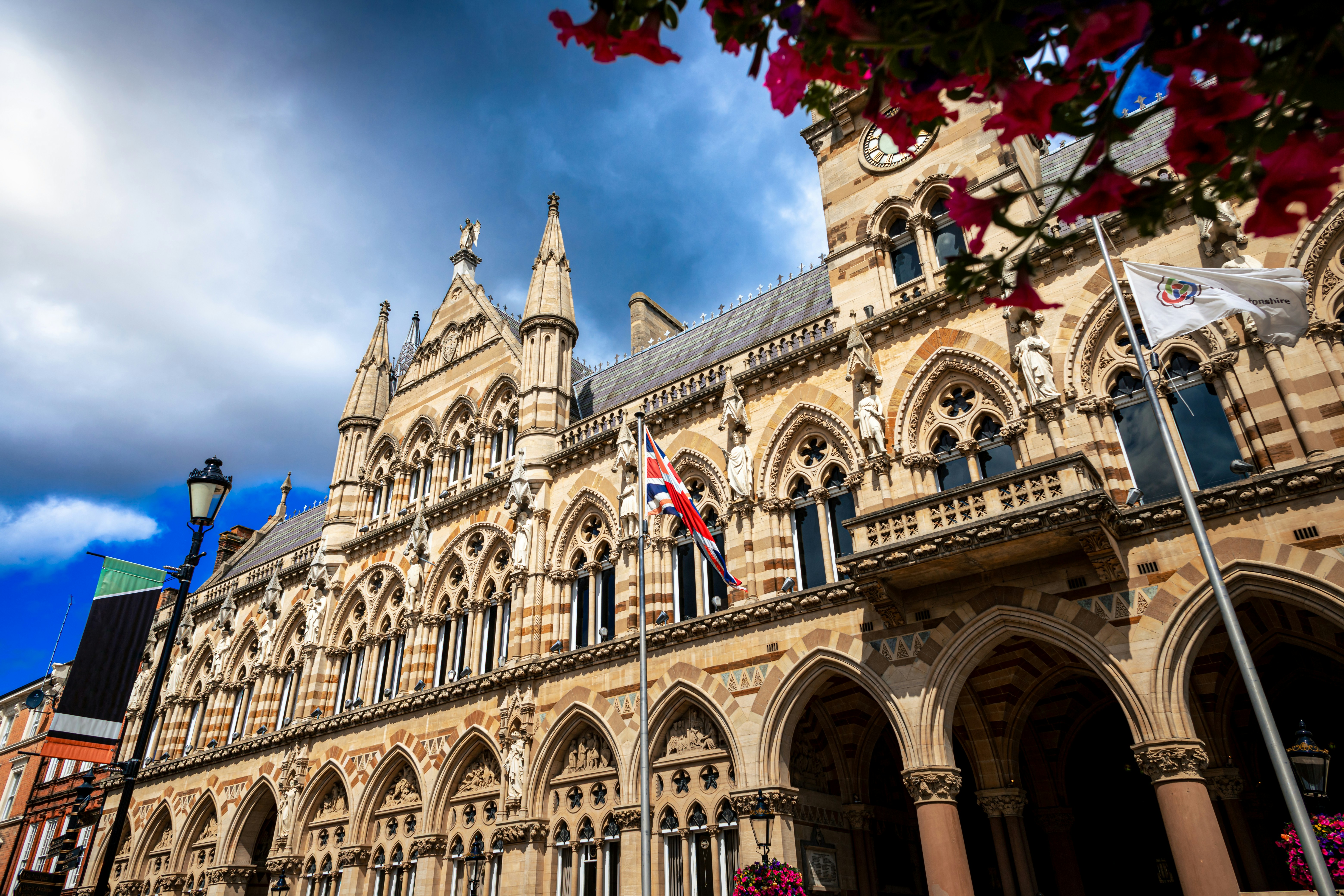 Beautiful, ornate building with flags and flowers.