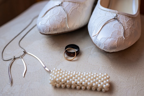 Wedding shoes, rings, and a necklace are displayed.