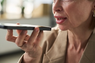 Woman is holding a phone to her mouth.