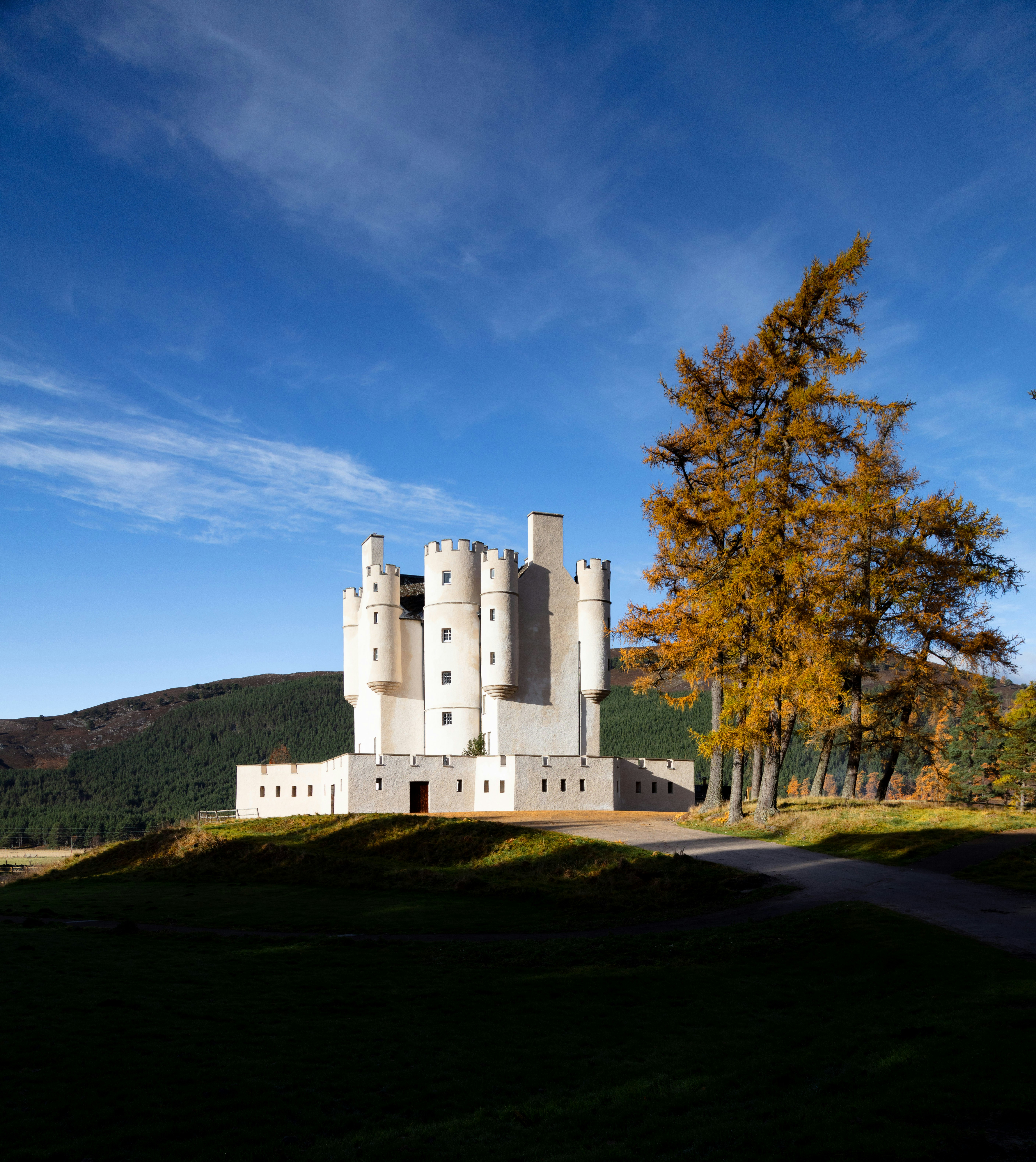 A white castle sits on a hill under a blue sky.