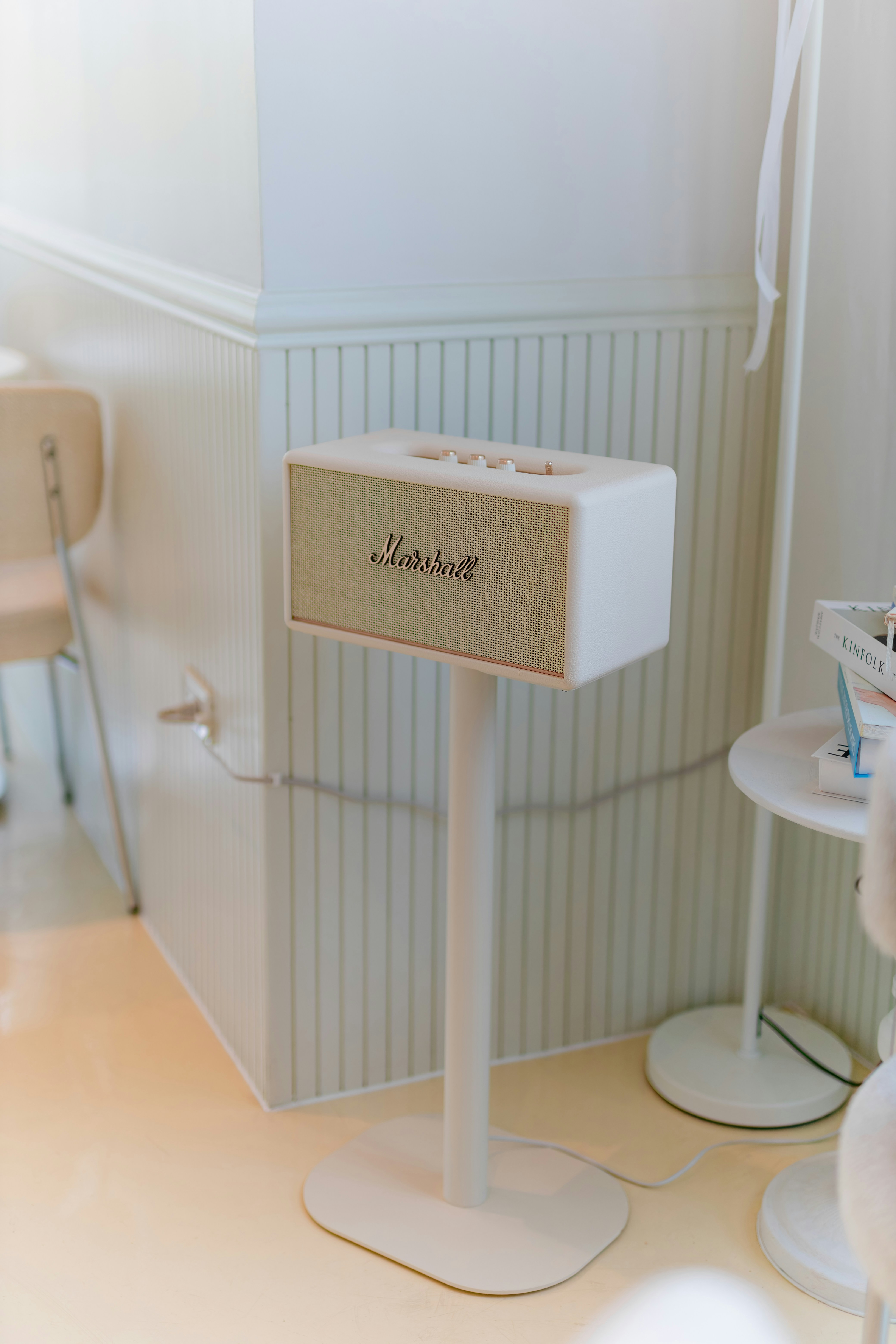 Ein Marshall-Lautsprecher sitzt auf einem weißen Ständer.