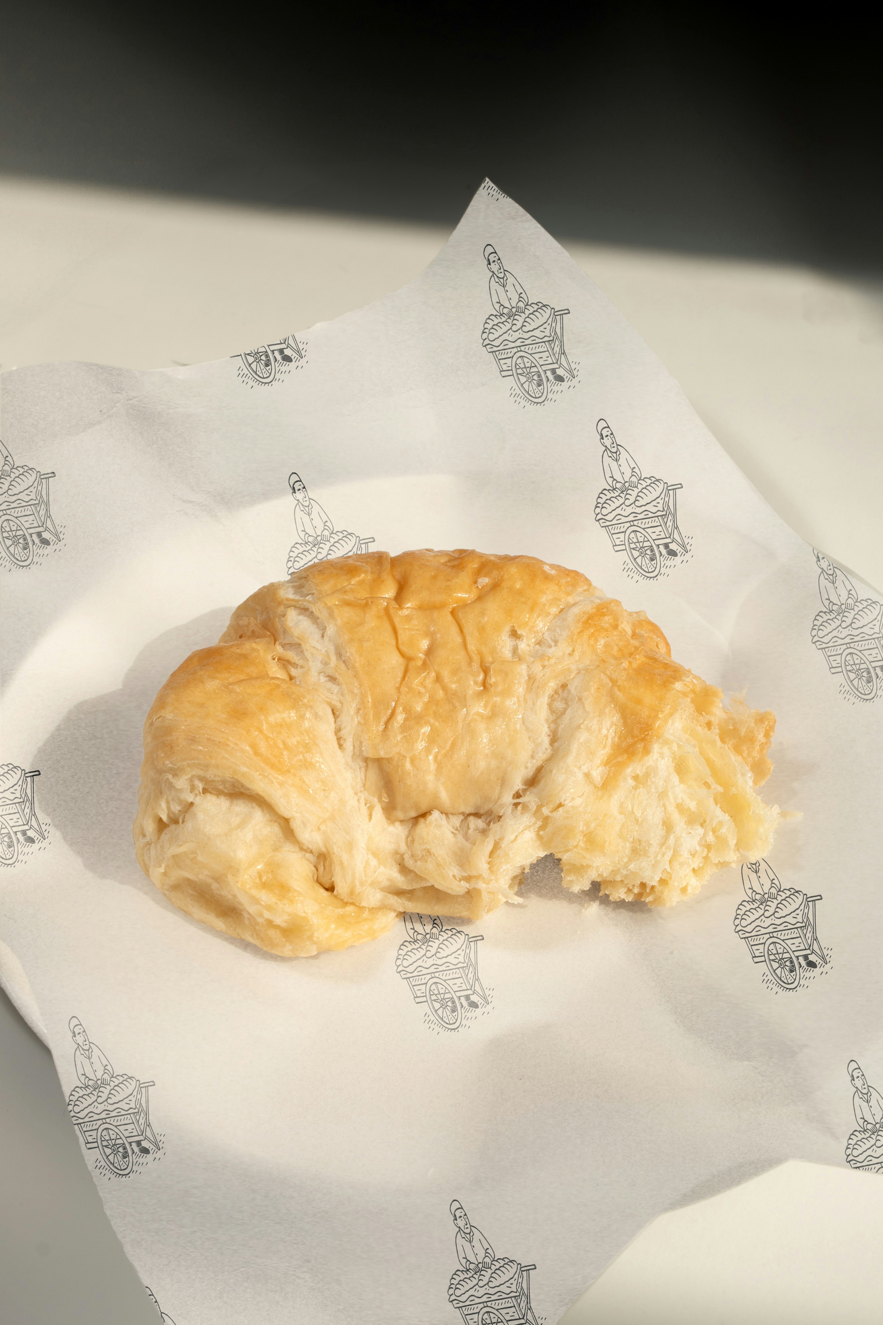 A delicious croissant lies on paper.