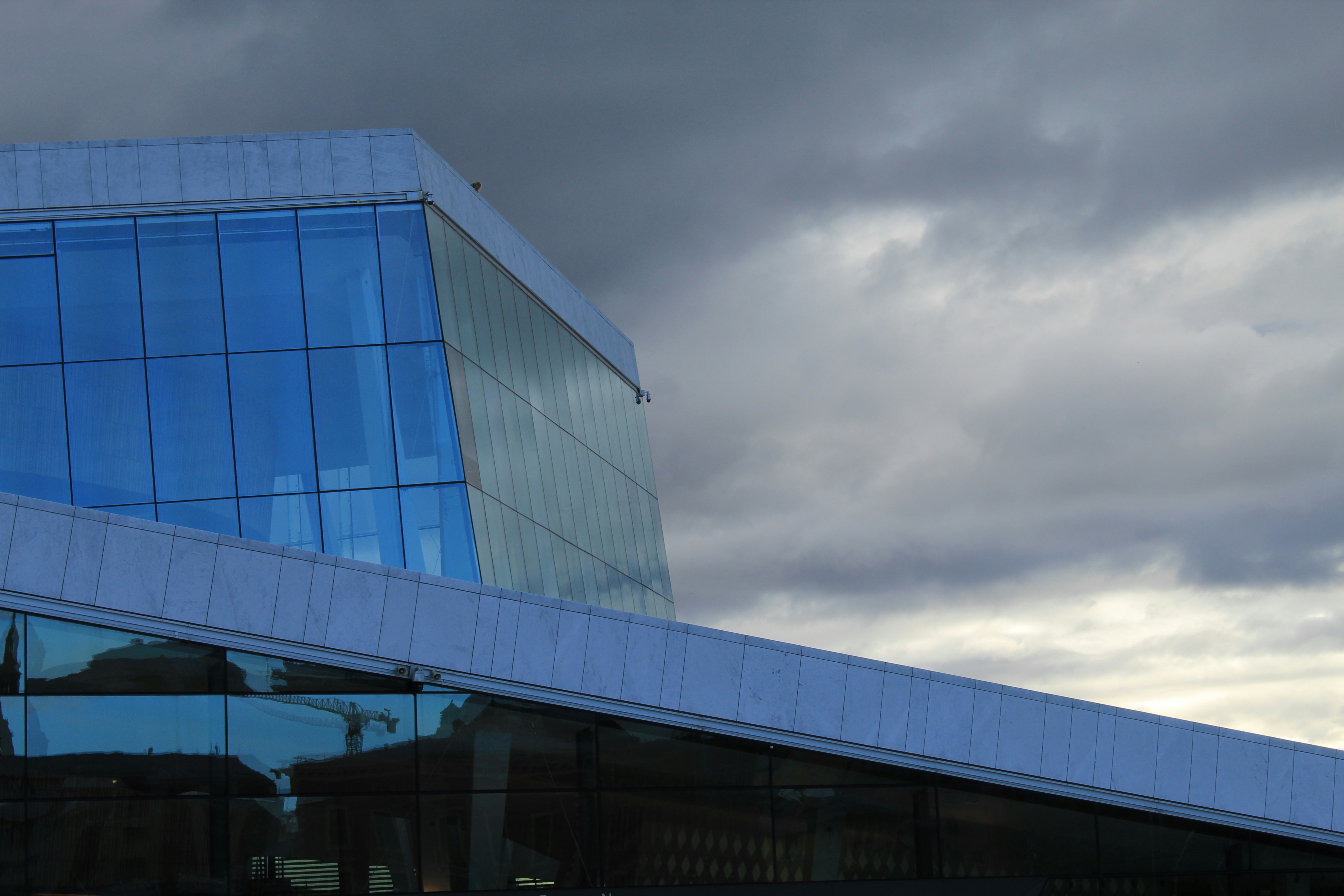 Modern building with glass and cloudy sky.