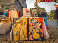 Art is displayed at an outdoor market.