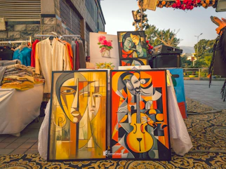 Art is displayed at an outdoor market.
