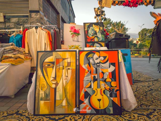 Art is displayed at an outdoor market.